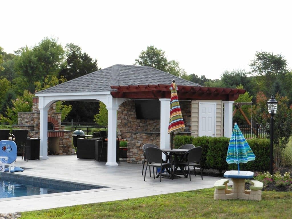 A gazebo with a pool and patio furniture.