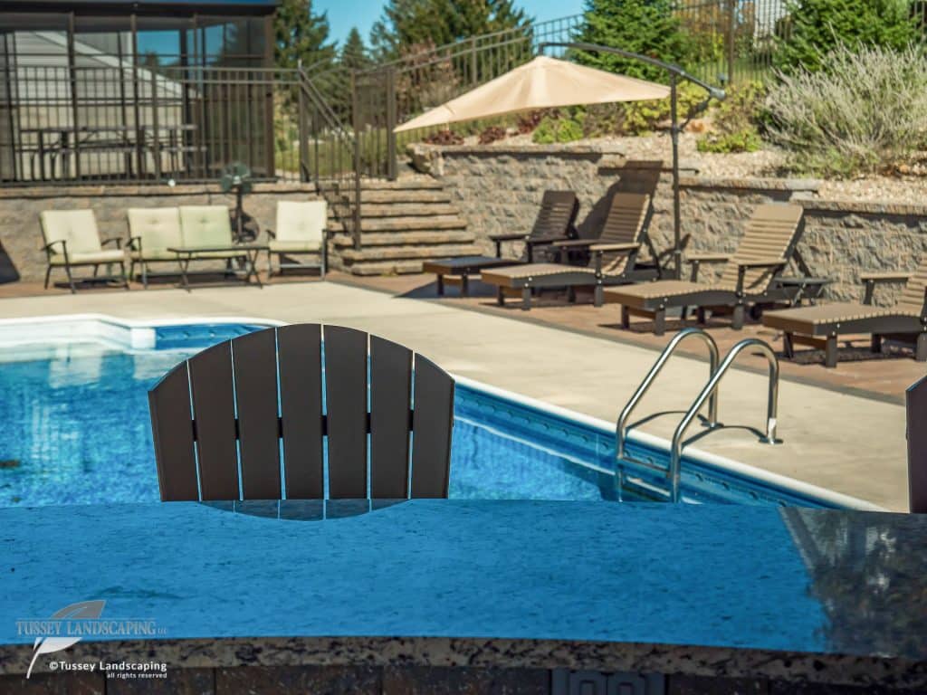 A swimming pool with chairs and a bar.
