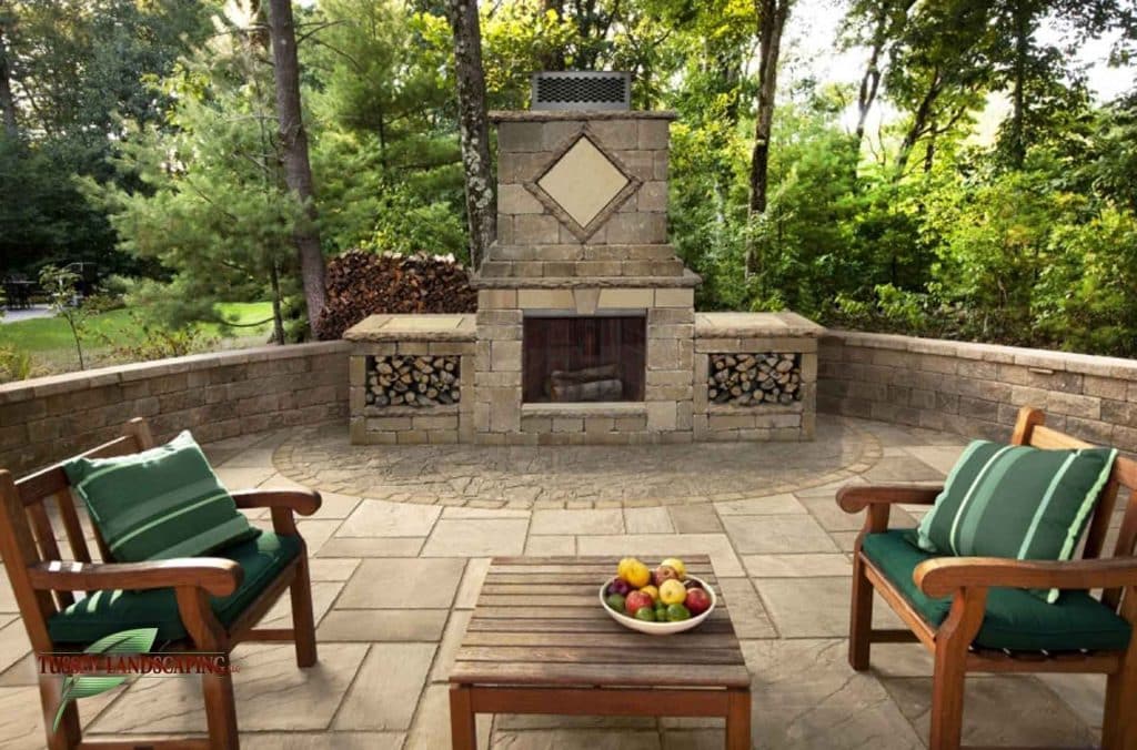 A patio with a fireplace and chairs.