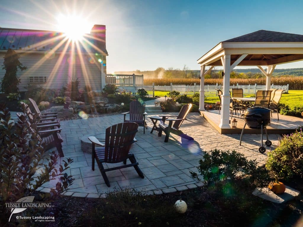 The sun is shining on a patio with a gazebo.