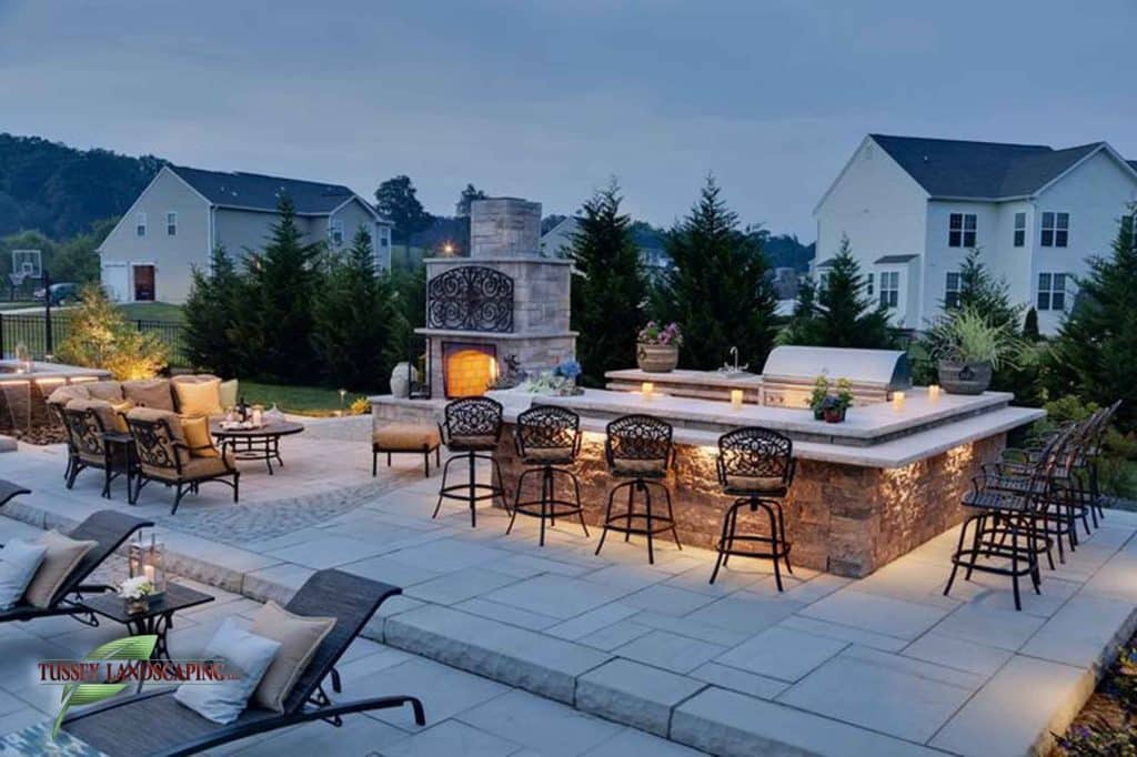 An outdoor kitchen with a fireplace and seating area.