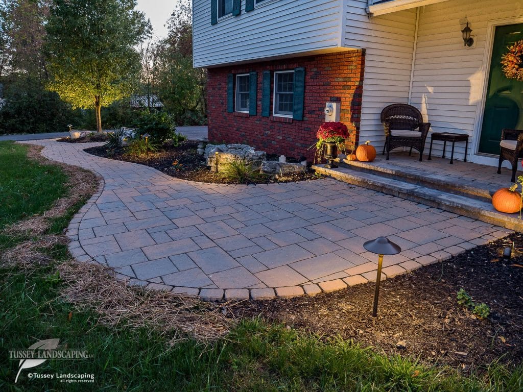 A paver patio with lights and a pumpkin on it.