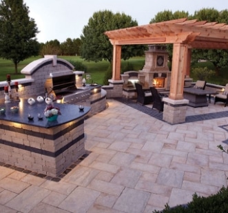 An outdoor kitchen with a fireplace and grill.