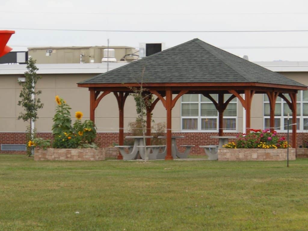 A wooden gazebo with a red roof.