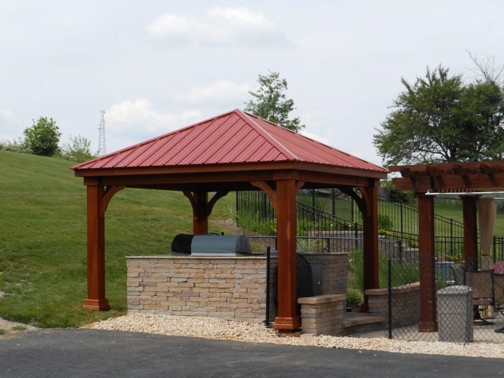 A wooden gazebo with a red roof.