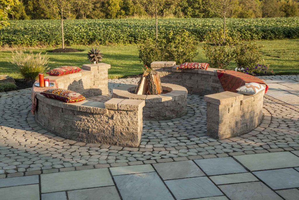 A patio with a fire pit in the middle.