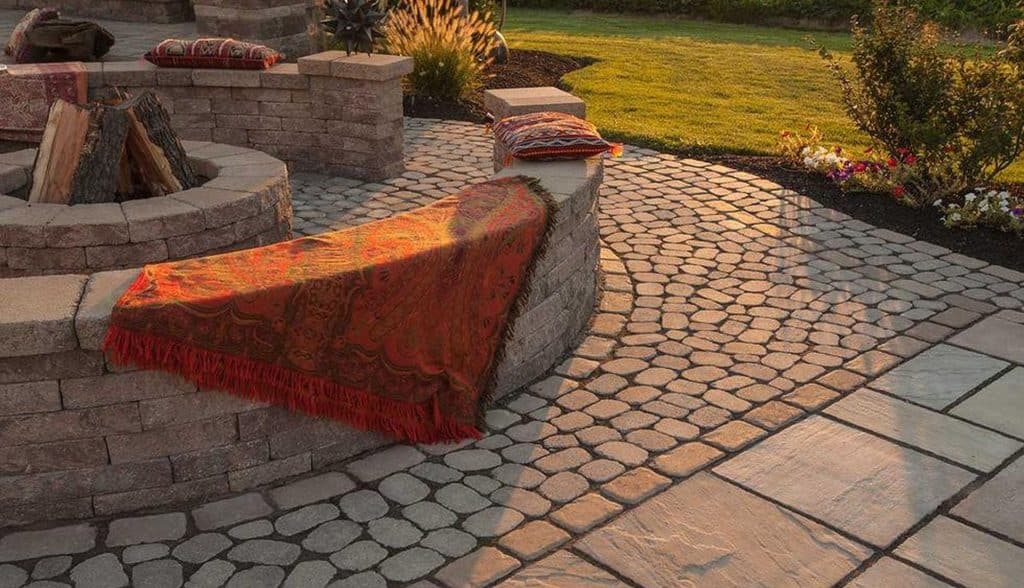 A patio with a fire pit and a blanket.