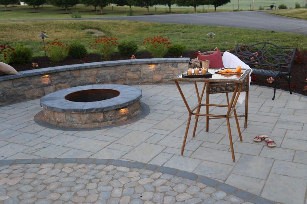 A patio with a fire pit and a table.