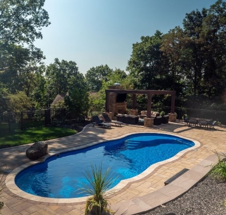 A backyard with a swimming pool and patio.