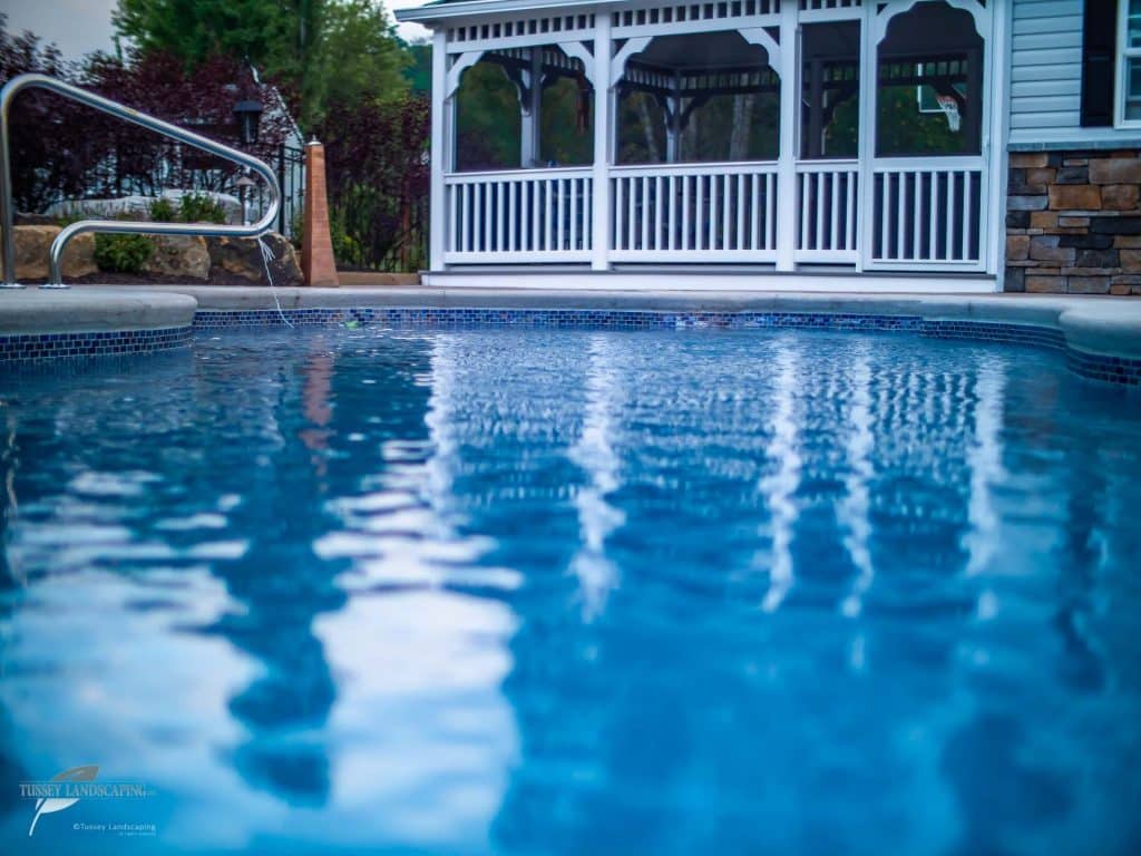 A pool with a gazebo in the background.
