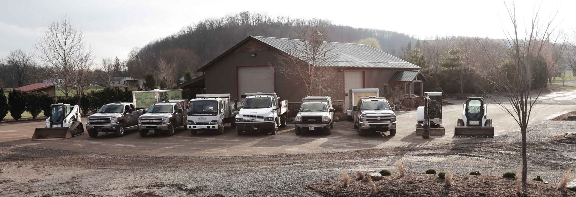 A group of trucks parked in front of a barn.