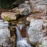 Large waterfall with landscaping and pond