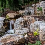 Large waterfall with landscaping and pond