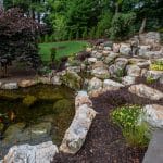 Large waterfall with landscaping and pond