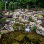 Large waterfall with landscaping and pond