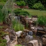 waterfall with pond and landscaping and hardscaping