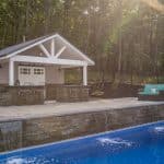 Fiberglass swimming pool with spillway paver patio and pool house