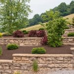 multi level retaining wall with landscaping and paver driveway