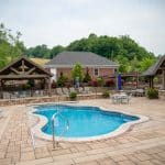 outdoor living space with pool, patio, pergola, pavilion, hot tub, pond
