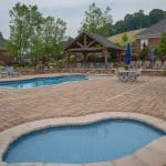 outdoor living space with pool, patio, pergola, pavilion, hot tub, pond