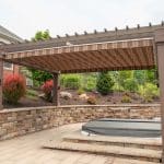 pergola over hot tub spa with retaining wall and landscaping