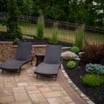paver patio with landscaping beds, retaining wall, and seating area