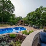 outdoor living space with fiberglass swimming pool, pergola, and paver patio