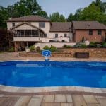 outdoor living space with fiberglass swimming pool, pergola, and paver patio