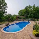 outdoor living space with fiberglass swimming pool, pergola, and paver patio