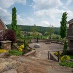 sunken fire pit area with retaining wall and paver patio with landscaping