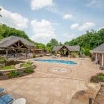 outdoor living space with pool, patio, pergola, pavilion, hot tub, pond