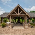 wood pavilion with outdoor kitchen and pillars on paver patio