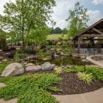 outdoor living space with pool, patio, pergola, pavilion, hot tub, pond