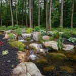 large pond landscaping with mountain boulders and pergola