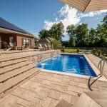 fiberglass swimming pool, spa hot tub, with hardscaping and paver patio