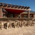 paver patio with outdoor kitchen under a pergola