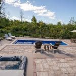 fiberglass swimming pool, spa hot tub, with hardscaping and paver patio