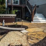 flag stone paver patio with retaining wall and mulch landscape bed