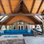 outdoor living space with in ground swimming pool, water falls, water feature, patio, pavers, pavilion, fire pit, natural stone stairs, and retaining walls
