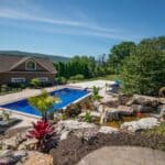 outdoor living space with in ground swimming pool, water falls, water feature, patio, pavers, pavilion, fire pit, natural stone stairs, and retaining walls