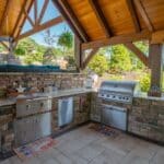 outdoor kitchen with stainless steel appliances in pavilion
