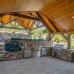 outdoor kitchen with stainless steel appliances in pavilion
