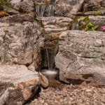 water feature with led lighting, mountain boulders, and waterfall