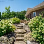 landscaping with natural stone stairs and paver sidewalk