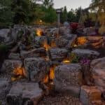 water feature with led lighting, mountain boulders, and waterfall