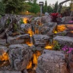 water feature with led lighting, mountain boulders, and waterfall