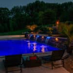 in ground swimming pool with LED lights and paver patio