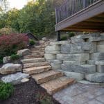 large retaining wall with landscaping and natural stone stairs