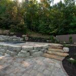 large retaining wall with landscaping and natural stone stairs