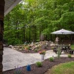pond with mountain boulders and landscaping and flagstone patio with outdoor living space